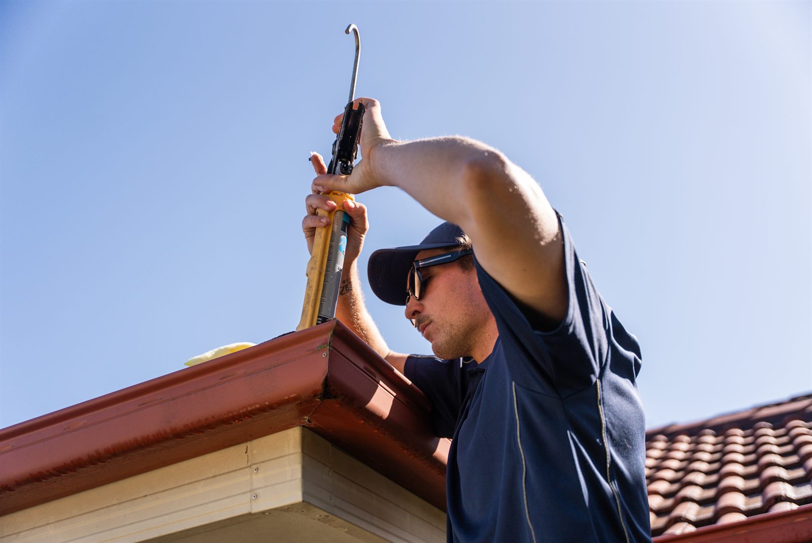 Elements Plumbing sealing a roof gutter joint - tidy, careful workmanship