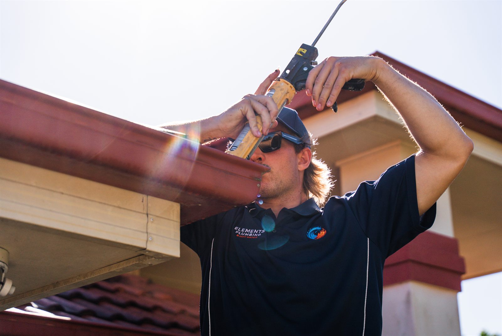 Elements Plumbing sealing a gutter joint during roofline maintenance