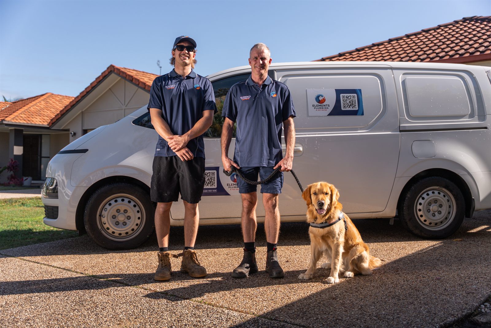 The Elements Plumbing team with Borris the golden retriever in front of the company van on the Sunshine Coast